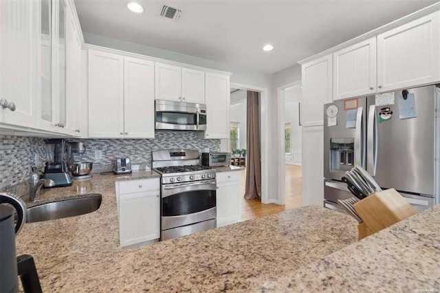 55 Hamptons Court Dr E Unit 55, Eastport, NY 11941 - kitchen featuring stainless steel appliances, a sink, tasteful backsplash, light stone countertops, and recessed lighting