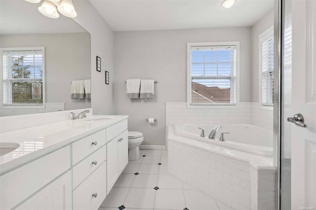 55 Hamptons Court Dr E Unit 55, Eastport, NY 11941 - bathroom featuring a garden tub, toilet, double vanity, baseboards, and tile patterned flooring