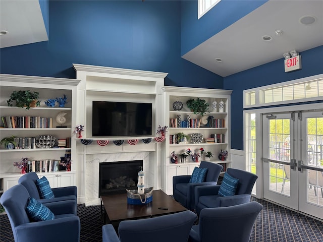 55 Hamptons Court Dr E Unit 55, Eastport, NY 11941 - living area with carpet, french doors, a high end fireplace, and high vaulted ceiling