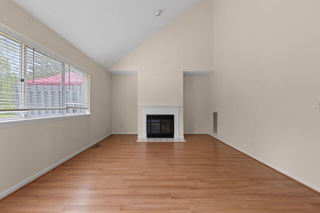 19 Cushing Grn S, Pawling, NY 12564 - unfurnished living room with light wood-style flooring, a fireplace with flush hearth, baseboards, and high vaulted ceiling