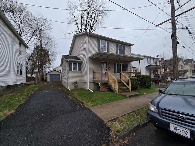 27 Thompson St, Port Jervis, NY 12771 - view of front of house featuring asphalt driveway, covered porch, an outdoor structure, and a detached garage
