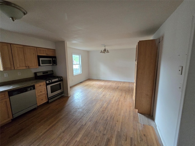 27 Thompson St, Port Jervis, NY 12771 - kitchen featuring appliances with stainless steel finishes, wood finished floors, brown cabinets, and baseboards