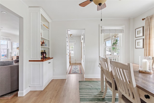28 Shore Rd, Babylon, NY 11702 - dining room with light wood-style flooring, plenty of natural light, a ceiling fan, crown molding, and baseboards