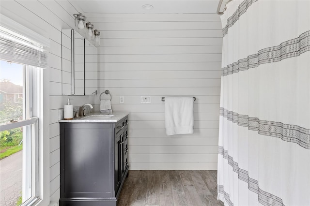 28 Shore Rd, Babylon, NY 11702 - bathroom with vanity, wood finished floors, healthy amount of natural light, and wooden walls