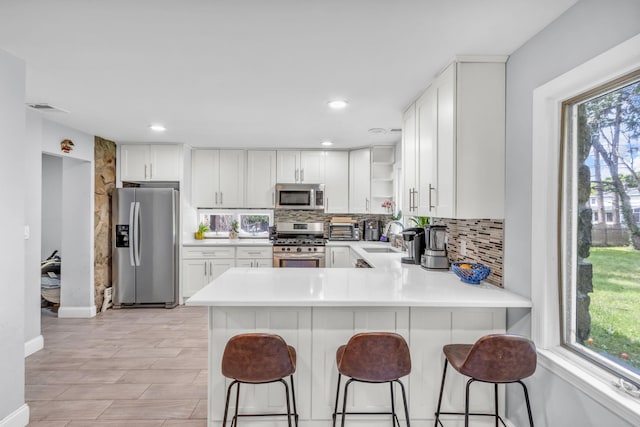 167 Grandview Ave, Nanuet, NY 10954 - kitchen featuring appliances with stainless steel finishes, tasteful backsplash, open shelves, light countertops, and recessed lighting