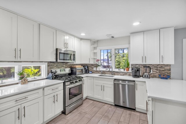 167 Grandview Ave, Nanuet, NY 10954 - kitchen featuring stainless steel appliances, backsplash, light countertops, white cabinetry, and recessed lighting