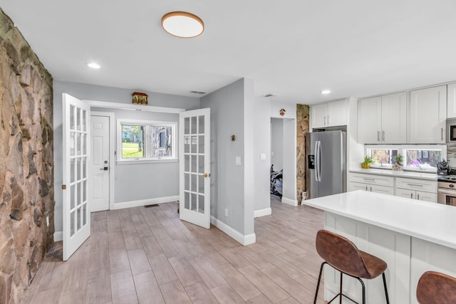 167 Grandview Ave, Nanuet, NY 10954 - kitchen featuring appliances with stainless steel finishes, french doors, light countertops, a kitchen breakfast bar, and white cabinetry