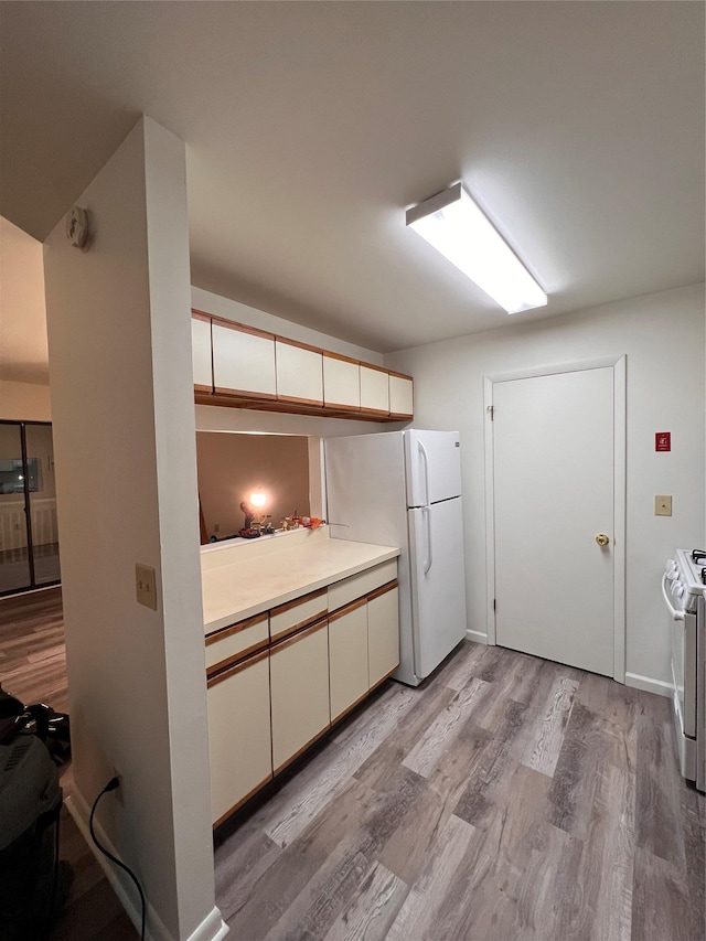 228 Concord Ln, Middletown, NY 10940 - kitchen featuring white appliances, light wood-style floors, light countertops, white cabinets, and baseboards
