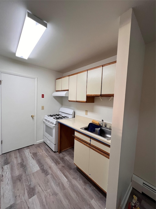 228 Concord Ln, Middletown, NY 10940 - kitchen featuring white gas stove, a sink, a baseboard radiator, light countertops, and light wood-style flooring