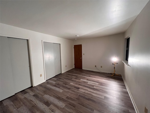 228 Concord Ln, Middletown, NY 10940 - unfurnished bedroom featuring multiple closets, dark wood-type flooring, and baseboards