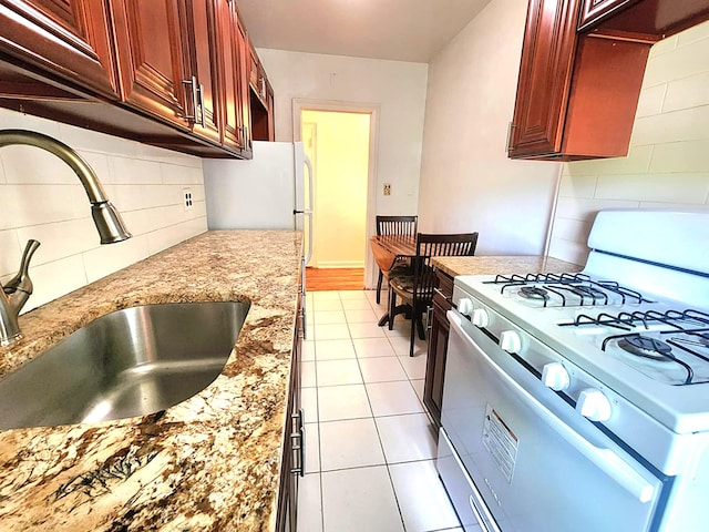 5607 31st Ave Unit 1B, Woodside, NY 11377 - kitchen with gas range gas stove, a sink, backsplash, light stone countertops, and dark brown cabinets