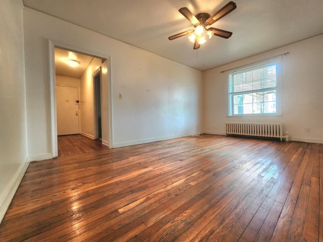 5607 31st Ave Unit 1B, Woodside, NY 11377 - spare room featuring radiator, dark wood-style floors, a ceiling fan, and baseboards