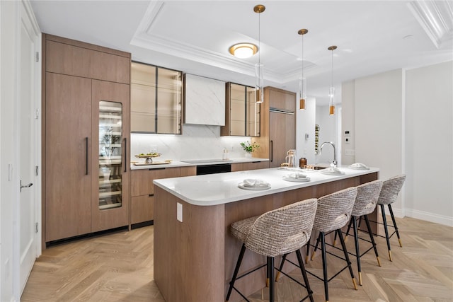 78-29 Austin St Unit Th1, Forest Hills, NY 11375 - kitchen with a raised ceiling, a center island with sink, a kitchen breakfast bar, light countertops, and baseboards