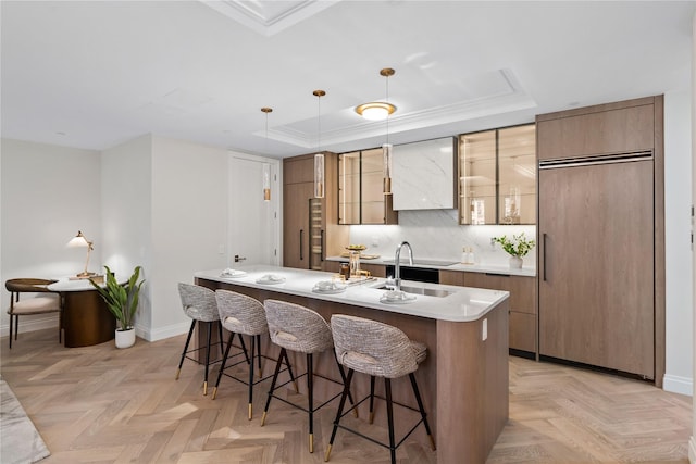 78-29 Austin St Unit Th1, Forest Hills, NY 11375 - kitchen featuring paneled built in fridge, a center island with sink, a tray ceiling, a breakfast bar, and baseboards