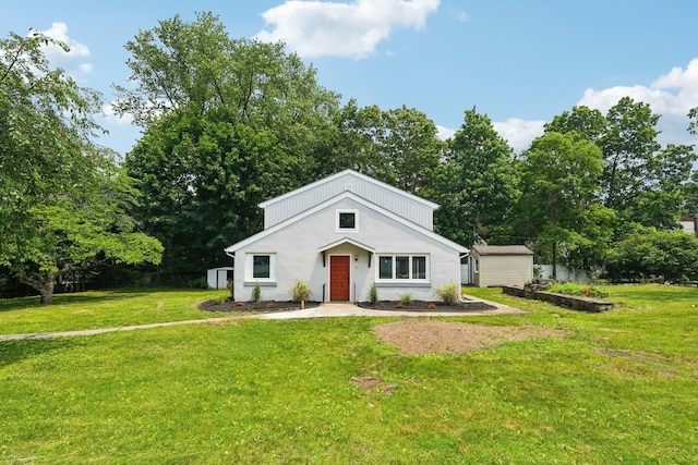 10 De Clark Pl, Nanuet, NY 10954 - view of front of house with a front yard, a storage shed, view of wooded area, and stucco siding