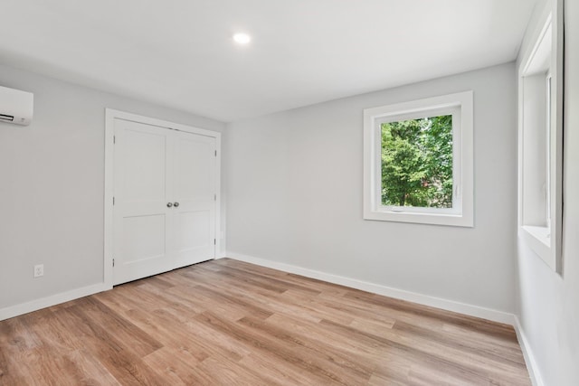 10 De Clark Pl, Nanuet, NY 10954 - unfurnished bedroom with light wood-type flooring, an AC wall unit, and a closet