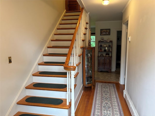 15 Orchard Rd, Poughkeepsie, NY 12603 - stairway with wood finished floors, ornamental molding, a baseboard radiator, and baseboards