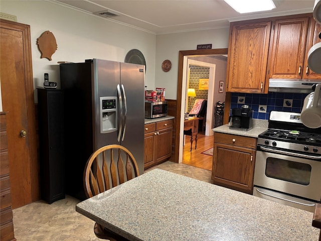 15 Orchard Rd, Poughkeepsie, NY 12603 - kitchen featuring appliances with stainless steel finishes, brown cabinetry, light countertops, under cabinet range hood, and crown molding