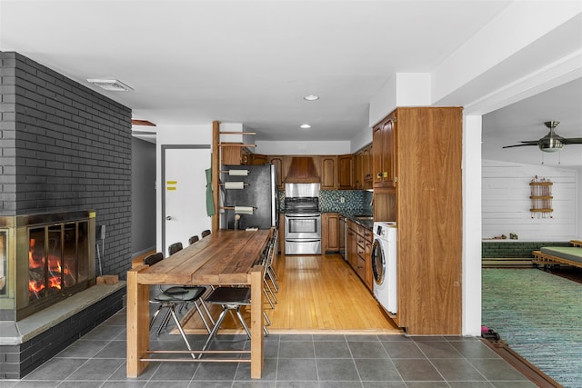 15 Relyea Ter, Wappingers Falls, NY 12590 - kitchen with stainless steel appliances, washer / clothes dryer, custom exhaust hood, a ceiling fan, and tile patterned floors