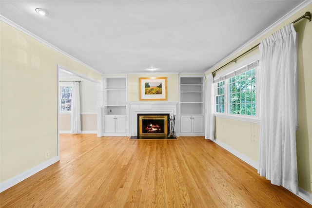4 Senate Pl, Larchmont, NY 10538 - unfurnished living room with crown molding, light wood finished floors, a fireplace with flush hearth, and built in shelves