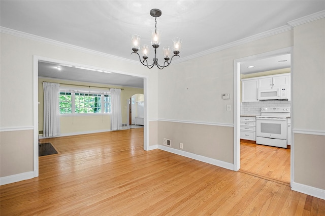 4 Senate Pl, Larchmont, NY 10538 - unfurnished dining area featuring light wood-type flooring, arched walkways, crown molding, and a chandelier