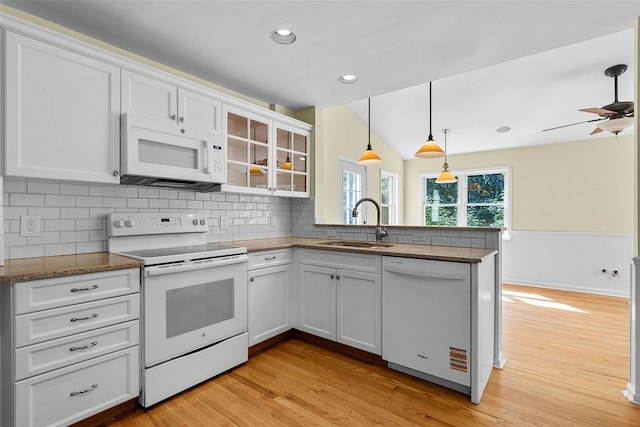 4 Senate Pl, Larchmont, NY 10538 - kitchen with white appliances, a peninsula, light wood-type flooring, white cabinetry, and wainscoting