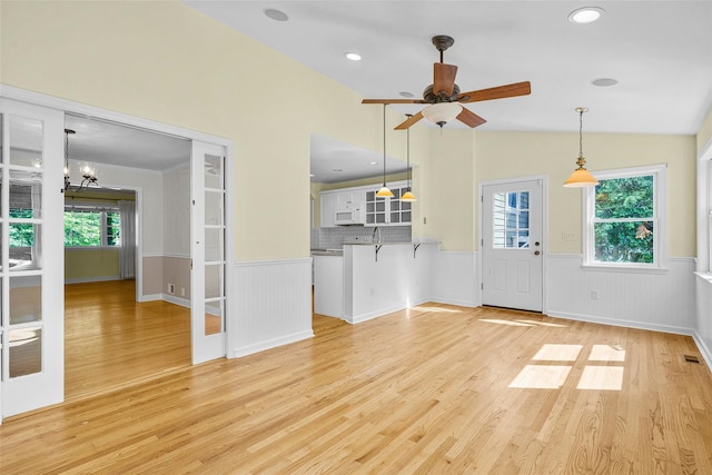 4 Senate Pl, Larchmont, NY 10538 - unfurnished living room with a wainscoted wall, light wood-type flooring, a chandelier, ceiling fan, and vaulted ceiling