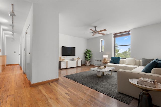 689 Fort Washington Ave Unit 4F, New York Manhattan, NY 10040 - living area with radiator, ceiling fan, light wood-style flooring, baseboards, and rail lighting