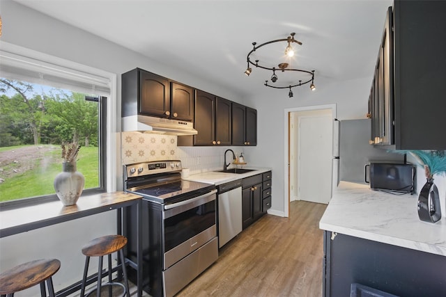 10 Millholland Dr Unit N, Fishkill, NY 12524 - kitchen featuring stainless steel appliances, light countertops, a sink, decorative backsplash, and light wood-type flooring