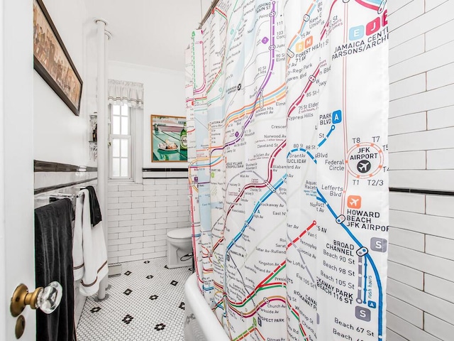 525 W 238th St Unit 1L, Bronx, NY 10463 - full bath featuring tile walls, ornamental molding, tile patterned floors, toilet, and wainscoting
