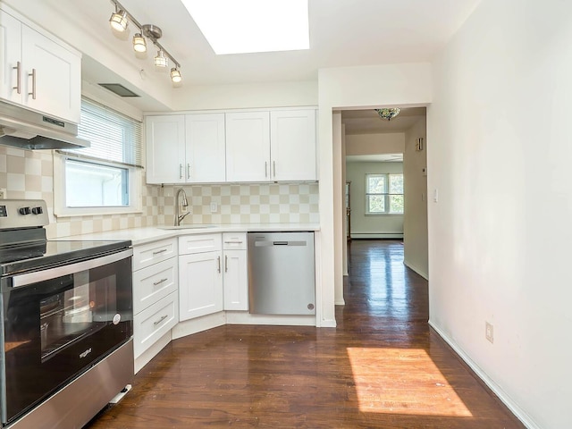 14 Marwood Rd S, Port Washington, NY 11050 - kitchen featuring stainless steel appliances, under cabinet range hood, a sink, a skylight, and light countertops