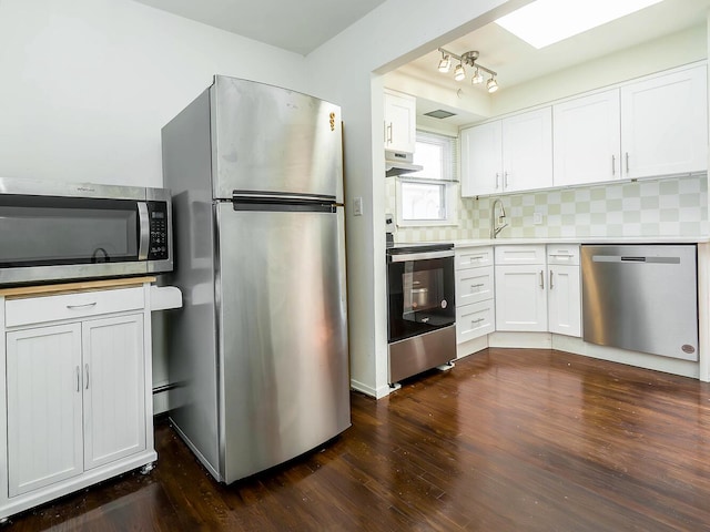 14 Marwood Rd S, Port Washington, NY 11050 - kitchen featuring stainless steel appliances, white cabinets, under cabinet range hood, and dark wood-type flooring