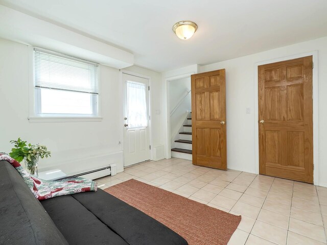 14 Marwood Rd S, Port Washington, NY 11050 - foyer entrance featuring light tile patterned floors, stairway, and a baseboard heating unit