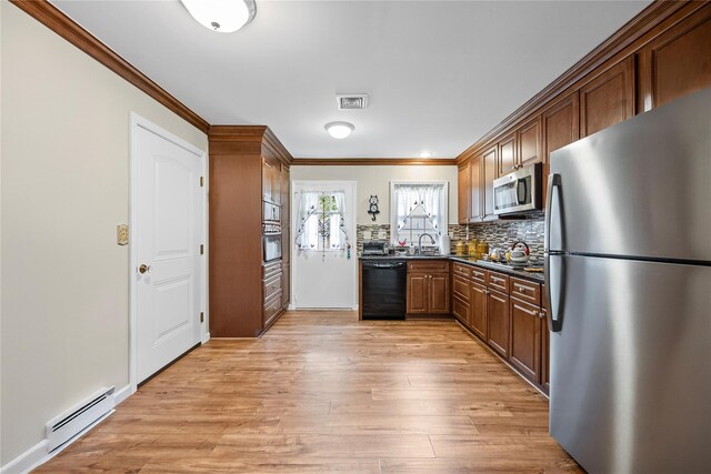 28 Trent Ct Unit B, Ridge, NY 11961 - kitchen with stainless steel appliances, dark countertops, ornamental molding, a baseboard radiator, and light wood-type flooring