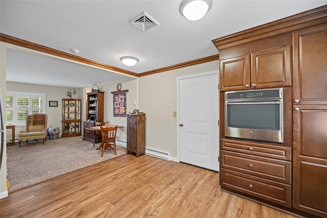 28 Trent Ct Unit B, Ridge, NY 11961 - kitchen featuring stainless steel oven, baseboard heating, light wood finished floors, a desk, and ornamental molding
