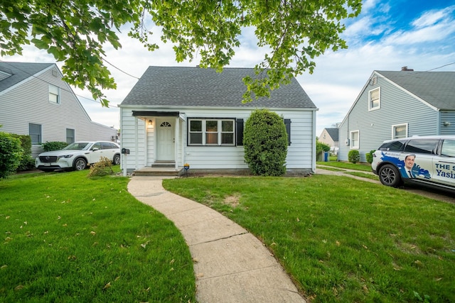 31 Peninsula Blvd, Valley Stream, NY 11581 - new england style home featuring roof with shingles and a front yard