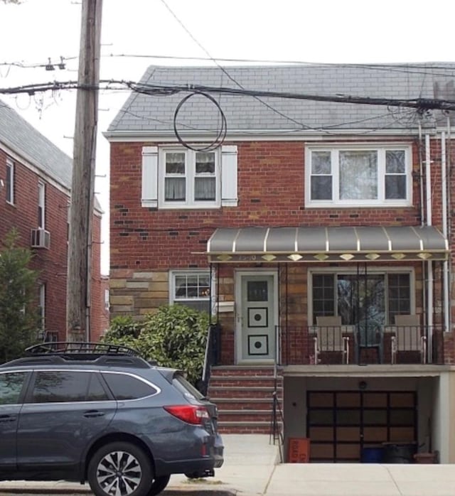 7510 Juniper Blvd S, Middle Village, NY 11379 - view of property with brick siding, a garage, and covered porch