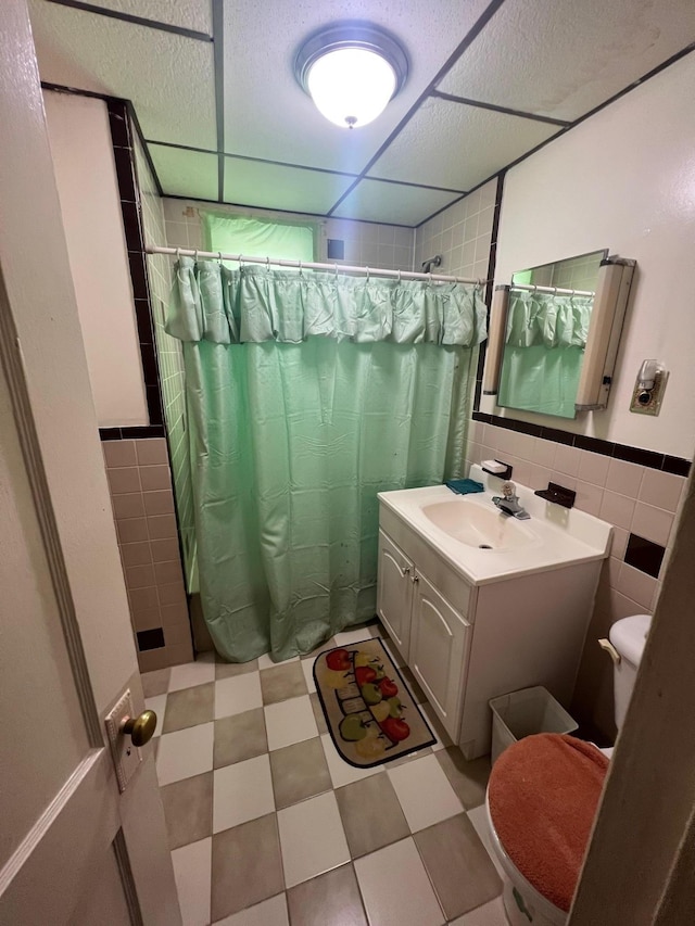 111-31 Lefferts Blvd, South Ozone Park, NY 11420 - bathroom with tile walls, toilet, vanity, curtained shower, and tile patterned floors