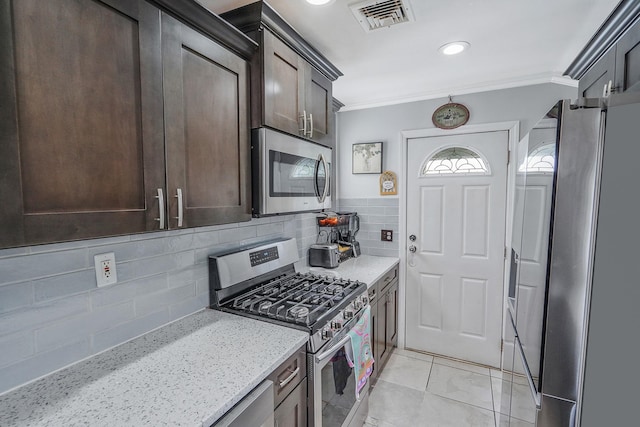 263 Claywood Dr, Brentwood, NY 11717 - kitchen with appliances with stainless steel finishes, dark brown cabinetry, crown molding, light stone countertops, and decorative backsplash