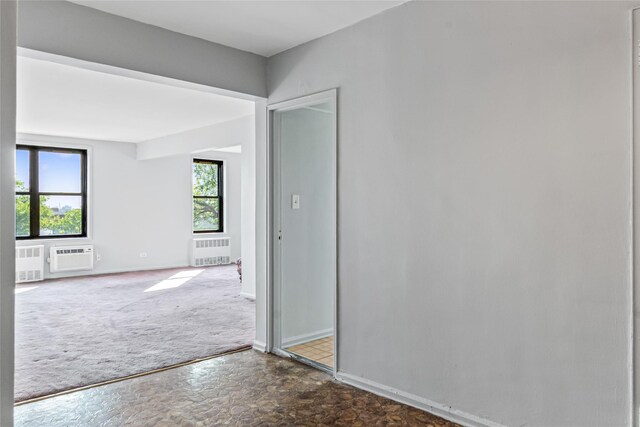 140-15 Holly Ave Unit 4E, Flushing, NY 11355 - empty room with radiator heating unit, carpet floors, baseboards, and an AC wall unit