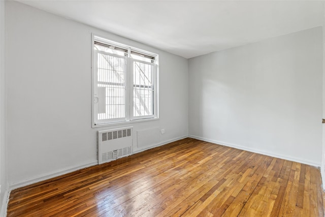 140-15 Holly Ave Unit 4E, Flushing, NY 11355 - unfurnished room featuring radiator heating unit, wood-type flooring, and baseboards