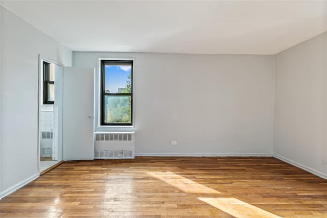 140-15 Holly Ave Unit 4E, Flushing, NY 11355 - unfurnished room featuring radiator, hardwood / wood-style floors, and baseboards