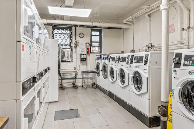 140-15 Holly Ave Unit 4E, Flushing, NY 11355 - shared laundry with estacked washer and dryer, washer and clothes dryer, a skylight, and light tile patterned floors