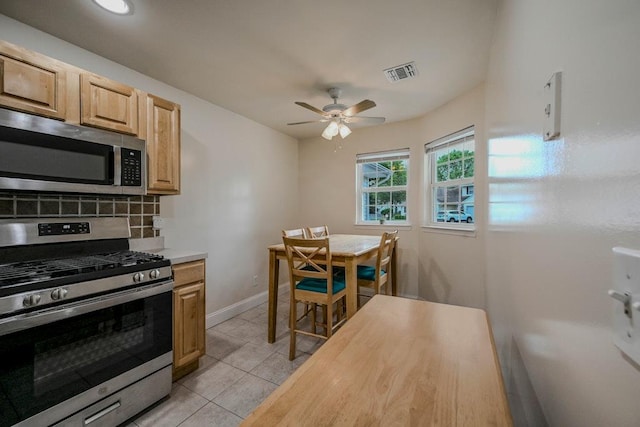 93 Mulberry Commons, Riverhead, NY 11901 - kitchen with stainless steel appliances, tasteful backsplash, light countertops, a ceiling fan, and light tile patterned floors