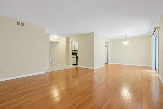 165 Carriage Ct Unit H, Yorktown Heights, NY 10598 - unfurnished living room featuring a chandelier and light wood finished floors