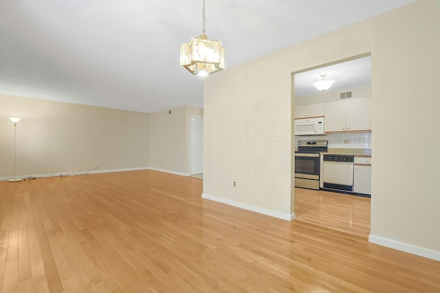 165 Carriage Ct Unit H, Yorktown Heights, NY 10598 - unfurnished living room featuring light wood-style floors and a chandelier