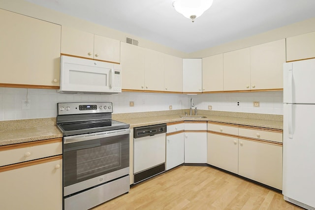 165 Carriage Ct Unit H, Yorktown Heights, NY 10598 - kitchen with white appliances, light countertops, light wood-type flooring, and decorative backsplash