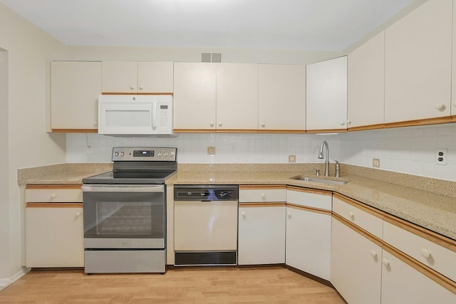 165 Carriage Ct Unit H, Yorktown Heights, NY 10598 - kitchen featuring white appliances, light wood-type flooring, light countertops, and backsplash