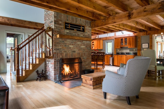 1900 Home, Sheffield, MA 01230 - living area featuring light wood-style flooring, wooden ceiling with exposed beams, stairway, and a brick fireplace