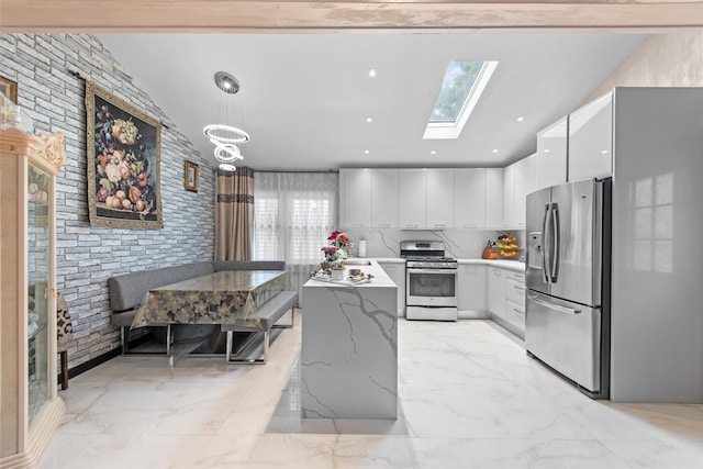 32 Henry Pl, Staten Island, NY 10305 - kitchen with stainless steel appliances, light marble finish flooring, white cabinetry, a skylight, and decorative light fixtures